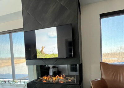 Electric fireplace in a black diamond pattern tile column. TV mounted above.